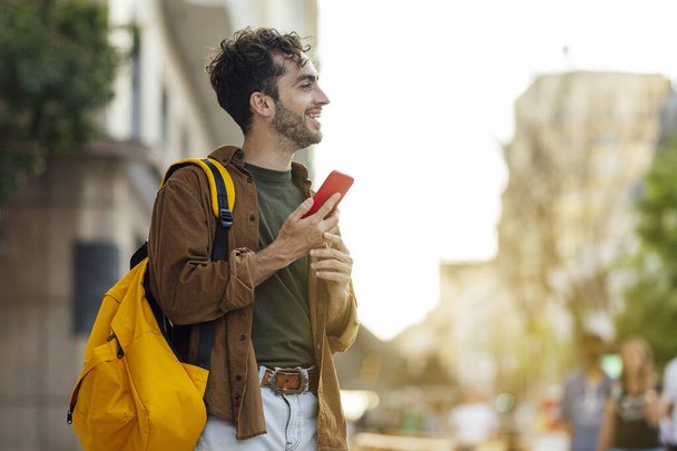 Retrato ao ar livre de belo jovem hipster homem com telefone móvel
. - Foto, Imagem