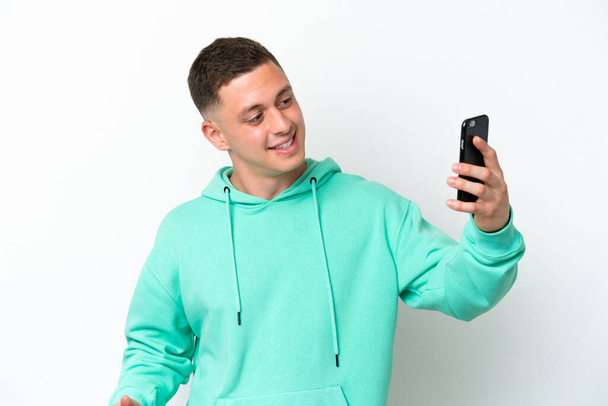 Young brazilian man isolated on white background making a selfie - Zdjęcie, obraz