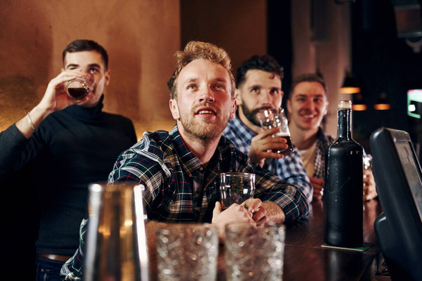 Expressive people watching soccer. Group of people together indoors in the pub have fun at weekend time. - Foto, Imagem