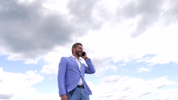 Mutlu profesyonel adam, cep telefonuyla gökyüzüne yaptığı konuşmadan sonra kazanıyor. - Video, Çekim