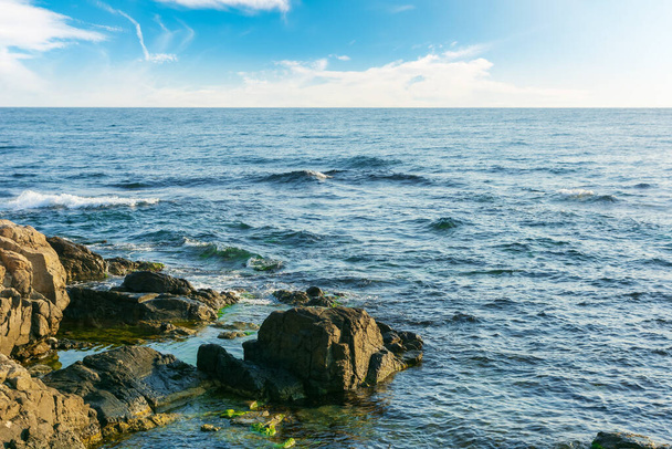 rocky sea coast in morning light. summer vacation concept. beautiful nature scenery with clouds on the blue sky above horizon - Photo, Image
