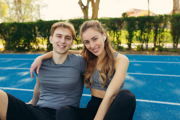 portrait of happy athletic couple after workout. The guy and the girl have a rest after exercises. The concept of a healthy lifestyle - Foto, immagini