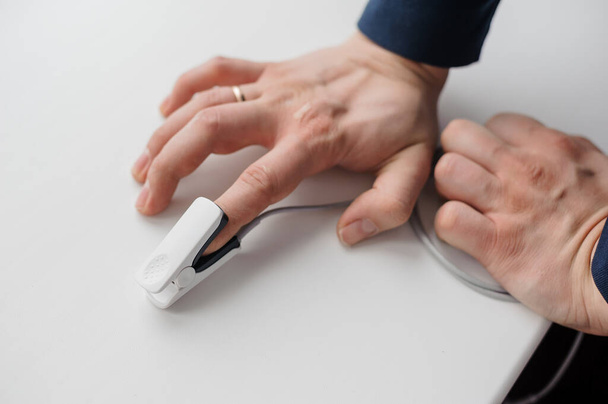Pulse oximeter on a background. Medical monitoring and diagnostic device for non-invasive measurement of capillary blood oxygen saturation - Foto, Imagen