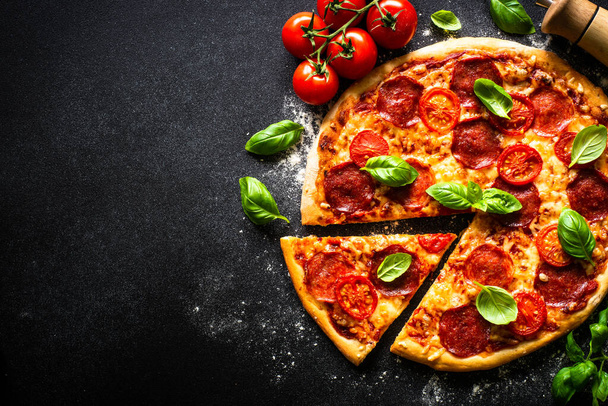 Pizza italiana tradicional con queso salami, tomates y albahaca. - Foto, Imagen