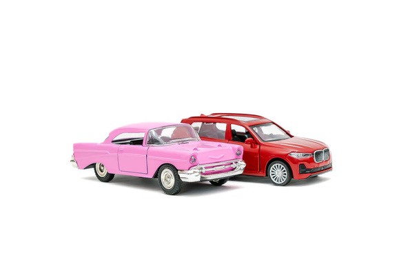 Colorful little mini red pink retro vintage plastic sedan car toy isolated on white background mockup with copy space, toys for children,for boys and girls,kids development, playing, childhood fun. - 写真・画像