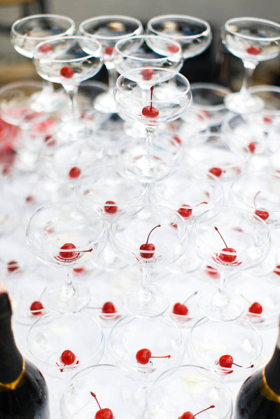Pyramid of martini glasses with cherries on the wedding table. - Φωτογραφία, εικόνα