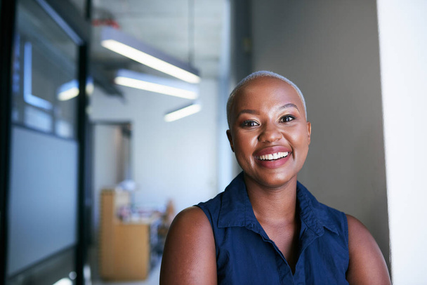 Una joven atractiva mujer negra sonríe en el pasillo de la oficina - Foto, Imagen