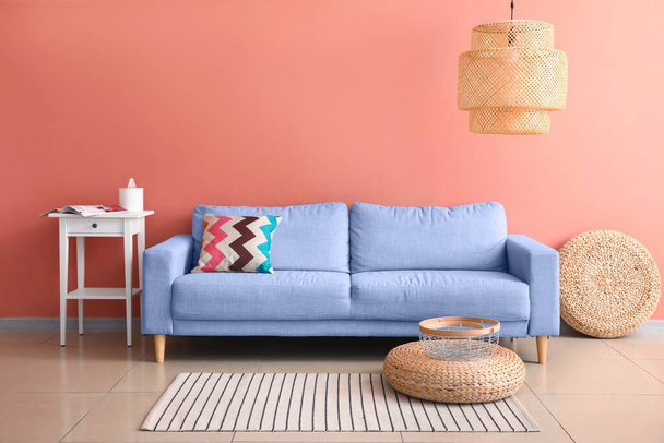 Cómodo sofá y mesa cerca de la pared rosa en la sala de estar - Foto, imagen