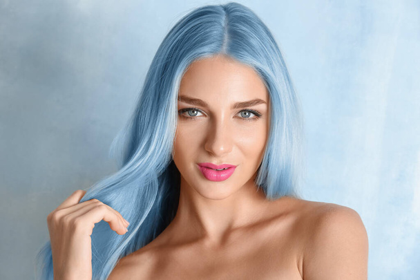 Beautiful young woman with blue hair on light color background - Photo, image