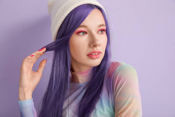 Gorgeous young woman with long violet hair on lilac background  - 写真・画像