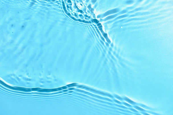 Texture of water with ripples on blue background, closeup - Fotó, kép