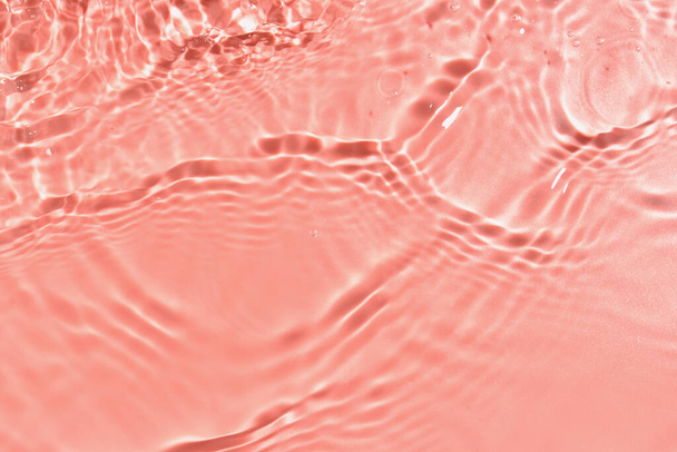 Textura de agua con ondulaciones sobre fondo rosa, primer plano - Foto, Imagen