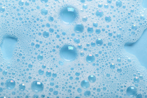 Вода з мильною піною на синьому фоні
 - Фото, зображення