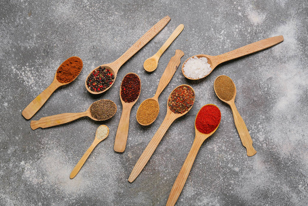 Spoons with aromatic spices on grey background - Foto, Imagen