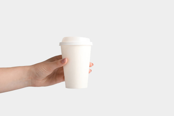 Woman holding takeaway paper cup on light background - Foto, immagini