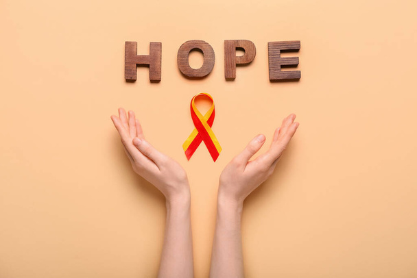 Woman with awareness ribbon and word HOPE on beige background. Hepatitis concept - Фото, зображення