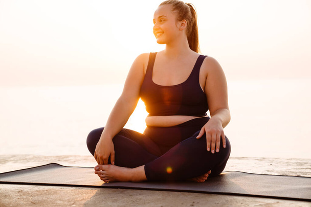 Ginger young woman smiling during yoga practice outdoors - Foto, Bild