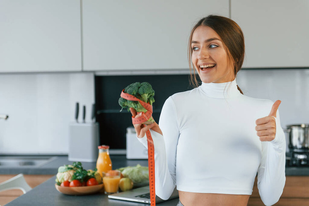 Young european woman is indoors at kitchen indoors with healthy food. - Foto, immagini