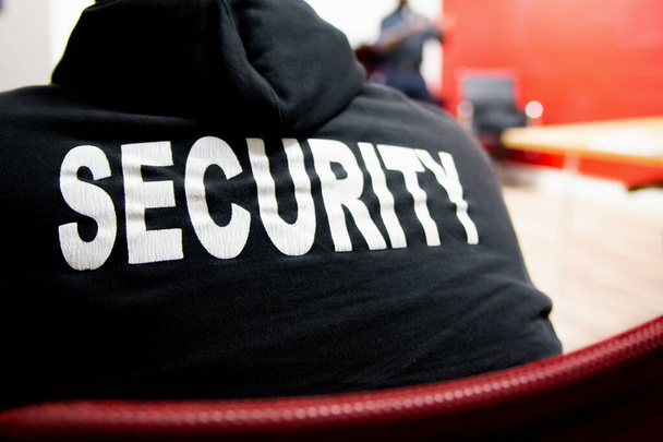 Şirket toplantı odasında üniformalı bir güvenlik görevlisinin dikiz görüntüsü.. - Fotoğraf, Görsel
