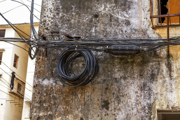 Close-up of a coil of outdoor electrical wiring in an old residential building - Fotoğraf, Görsel