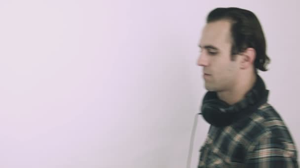 Crazy young man listening to loud music on headphones - Video, Çekim