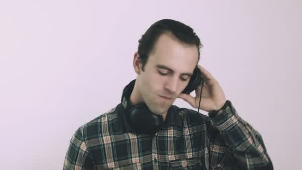 Young male Dj listening to music on headphones - 映像、動画