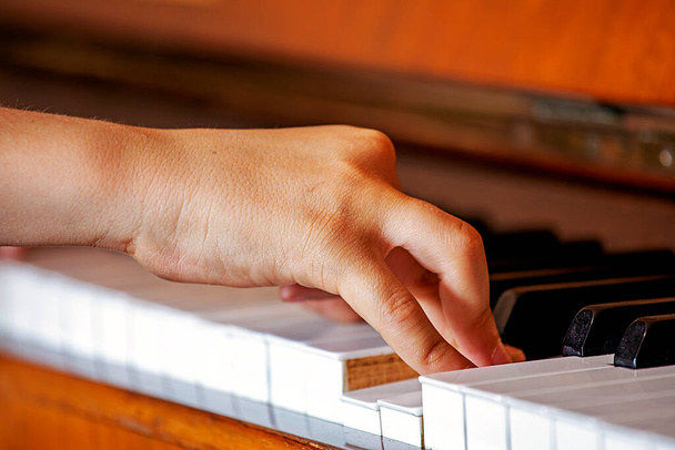ujjak a jobb kezét egy fiatal zongorista játszik gyakorlatok a fehér billentyűk a zongora, zenei oktatás - Fotó, kép