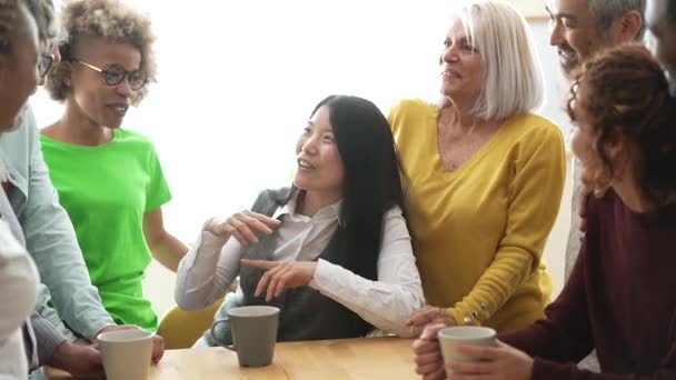 groep van gelukkige multiraciale mensen van verschillende leeftijden praten in de keuken, plezier hebben met een kopje koffie thuis - Video