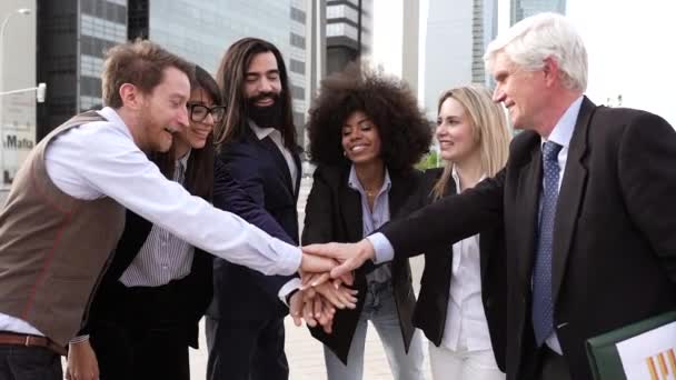 group of happy business people of different ages join hands as a team outdoors - Metraje, vídeo