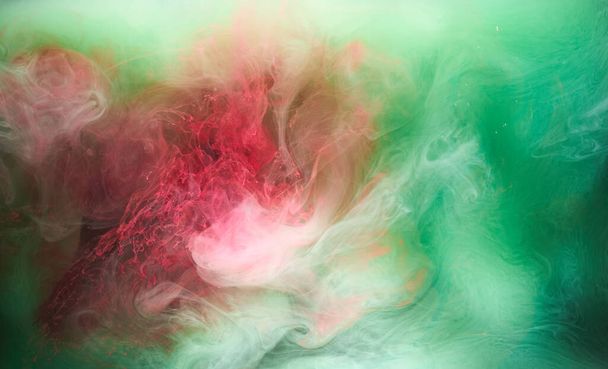 Green pink smoke on black ink background, colorful fog, abstract swirling touch ocean sea, acrylic paint pigment underwater - Fotoğraf, Görsel