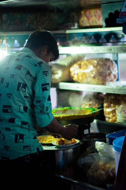 Zdjęcie ulicznego sprzedawcy sprzedającego bhel puri na indyjskich ulicach (Bhelpuri to pikantna przekąska pochodząca z Indii, a także rodzaj chaatu) - Zdjęcie, obraz