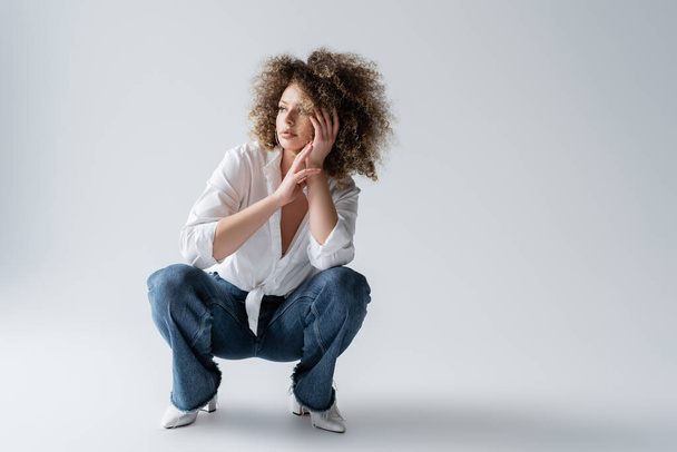 Stylish curly model posing on white background  - Valokuva, kuva