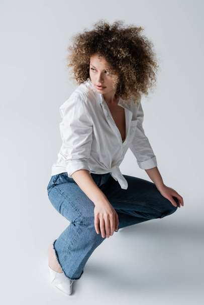 Pretty curly model posing on white background  - Foto, afbeelding