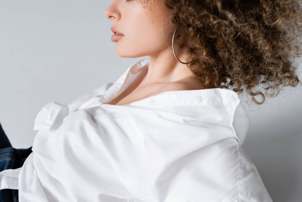 Cropped view of curly woman in blouse on white background  - Φωτογραφία, εικόνα