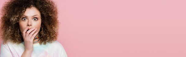 Portrait of young shocked woman covering mouth isolated on pink, banner  - Foto, imagen