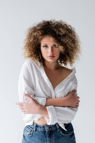 Portrait of young curly woman in blouse looking at camera isolated on white  - Фото, зображення