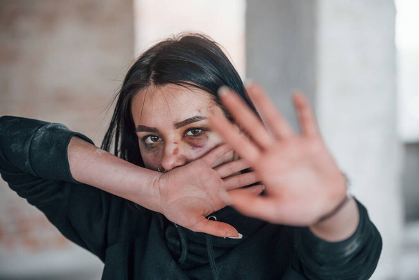 Stop the violence. Portrait of beaten young woman with bruise under eye indoors in abandoned building. - Φωτογραφία, εικόνα