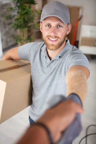 handshake of entrepreneur sme to receive parcel from deliveryman - Фото, зображення