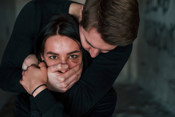 Man's hand covering her mouth. Kidnapped woman is threatened by guy. - Fotoğraf, Görsel