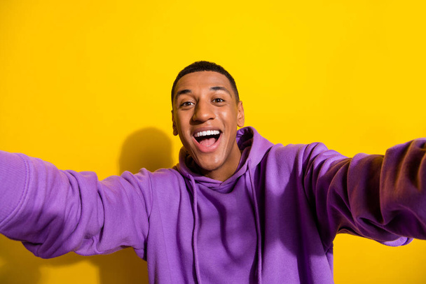 Photo of kind friendly positive young man take selfie make video vlog shooting his lifestyle isolated on yellow color background - Fotoğraf, Görsel