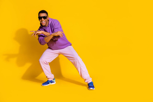 Full length body size view of attractive cheerful guy having fun dancing street copy space isolated over bright yellow color background - Foto, imagen