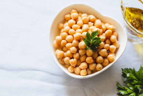 Cooked chickpeas in white bowl. Ingredient for Tasty vegetarian food. Boiled chickpeas, selective focus - Photo, Image