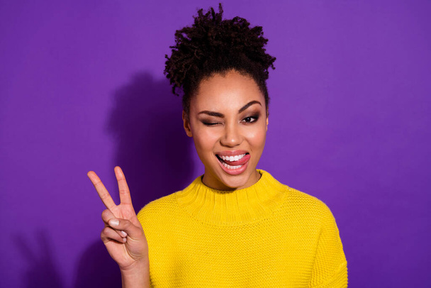 Portrait of pretty positive girl hand show v-sign eye wink tongue out isolated on purple color background - Foto, Bild