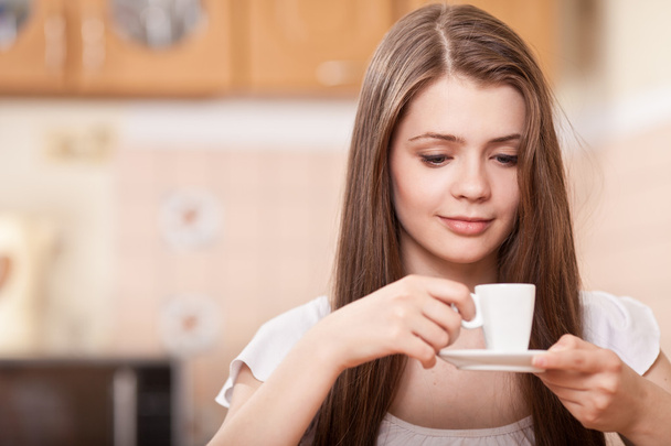 Красива щаслива молода жінка п'є каву вдома
 - Фото, зображення