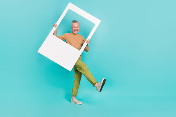 Full length portrait of excited positive person hold paper set card walk isolated on turquoise color background - 写真・画像