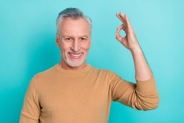Portrait of handsome cheerful man arm fingers demonstrate okey symbol isolated on turquoise color background - Foto, Imagem