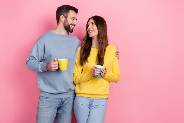 Portrait of attractive cheerful couple drinking beverage bonding copy space isolated over pink pastel color background - Фото, изображение