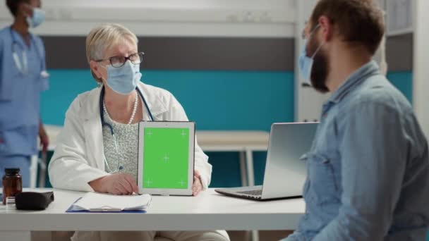 Physician and man looking at digital tablet with greenscreen - Footage, Video