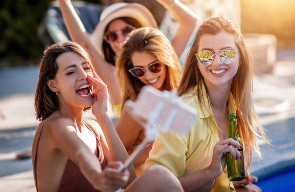 Group of  girls take selfie by swimming pool.Party, lifestyle and leisure time concept. - Foto, Bild