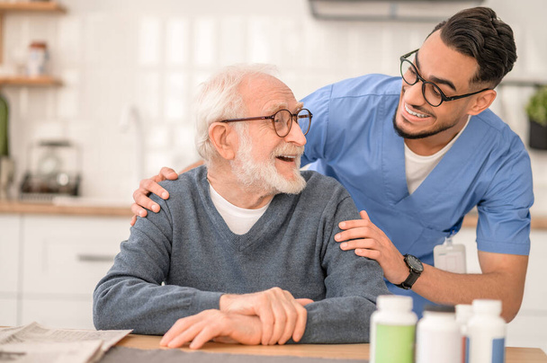 Caring healthcare worker embracing an elderly person - Photo, Image